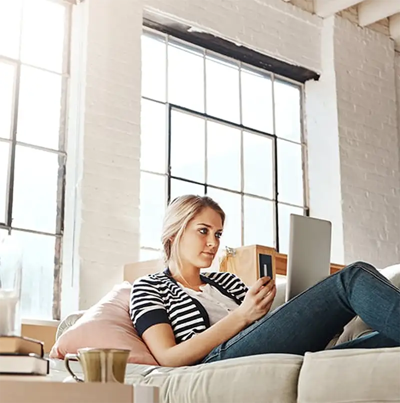 woman sitting on the couch shopping online