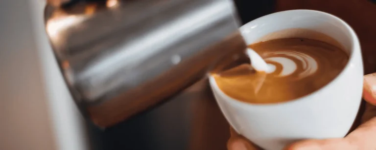 pouring cream into coffee drink