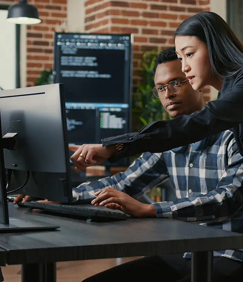 coworkers working together at a desk with computer