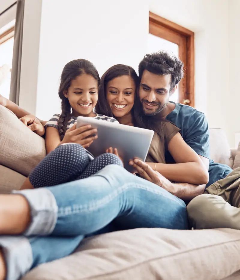 family sitting on a couch with a laptop