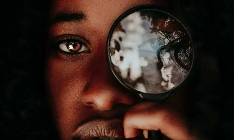 person looking through magnifying glass