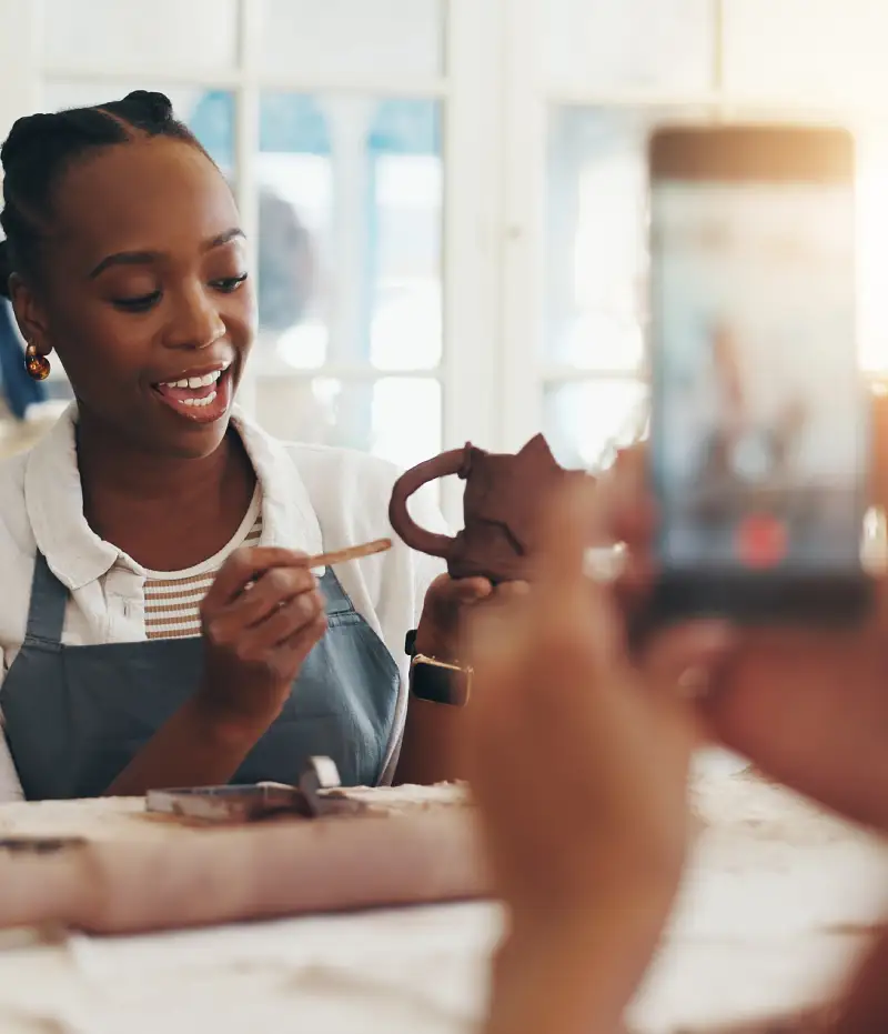 woman recording a how to video with clay mug