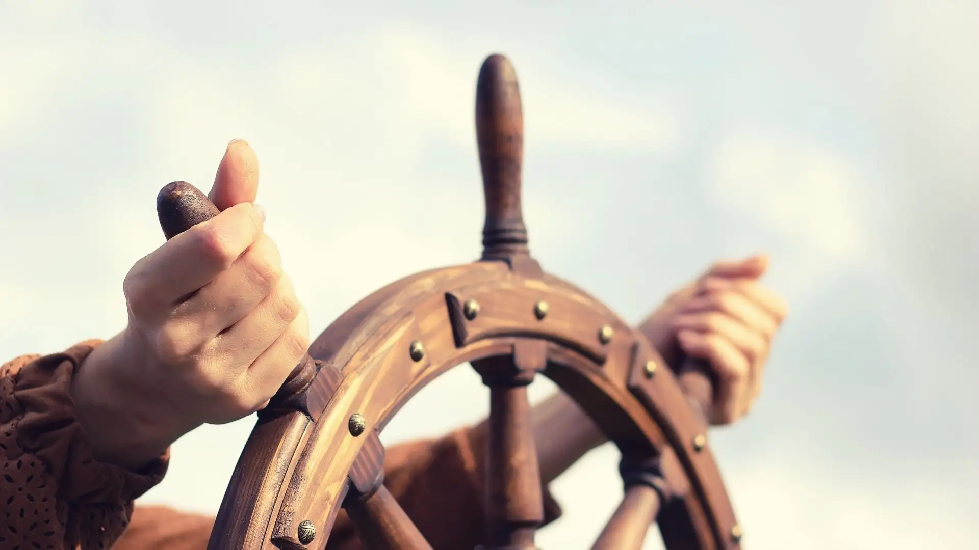 someone holding a ship's wheel
